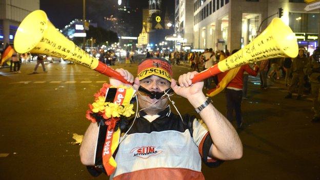 A German fan celebrates with vuvuzelas in Berlin after Germany won the 2014 World Cup final