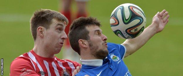 Jonathan Boyle of Warrenpoint competes against Linfield's Stephen Lowry