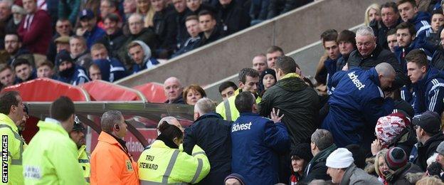 Police and stewards surround the Sunderland dug-out during the defeat by Aston Villa
