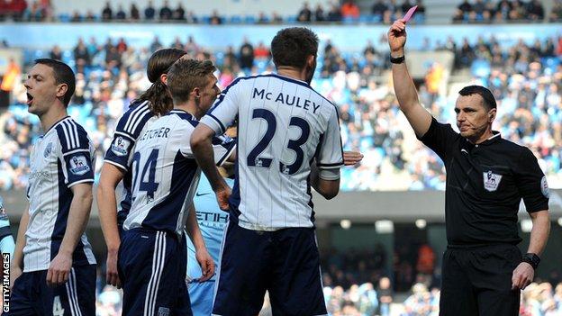 Referee Neil Swarbrick shoes a red card to the wrong player during the Manchester City-West Brom game
