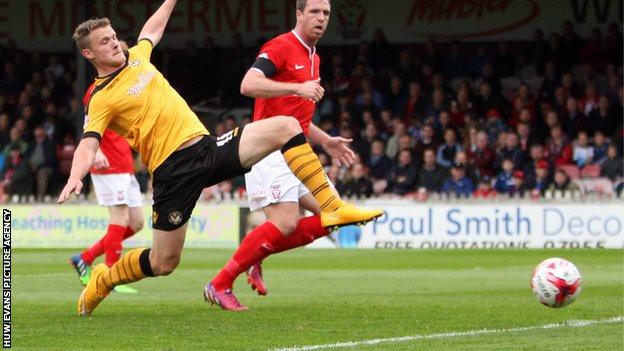 Yan Klukowski of Newport County stretches out to challenge for a cross