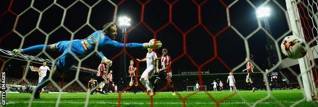 Brentford keeper David Button dives to try and keep out Fernando Amorebieta's late goal
