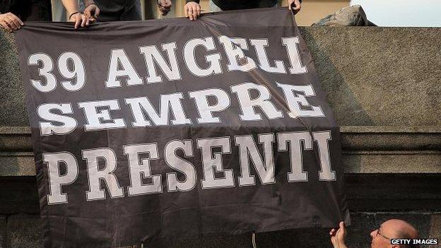 Juventus supporters hold a banner reading "39 angels forever" outside the Gran Madre di Dio church in Turin