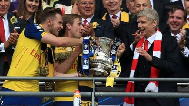 Aaron Ramsey (L) hands the FA Cup to Arsenal manager Arsene Wenger at Wembley