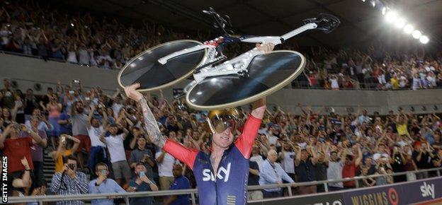 Sir Bradley Wiggins holds his bike aloft after breaking the record