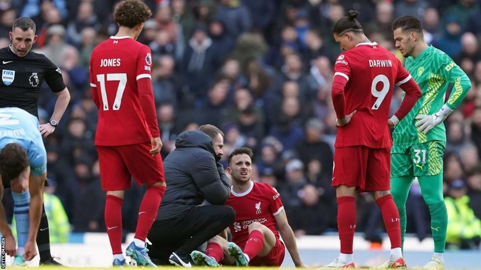 Liverpool forward Diogo Jota receives treatment during a match against Manchester City