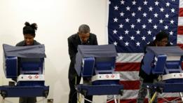 Obama votando entre dos mujeres