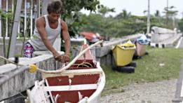 Hombre ata bote a un muelle
