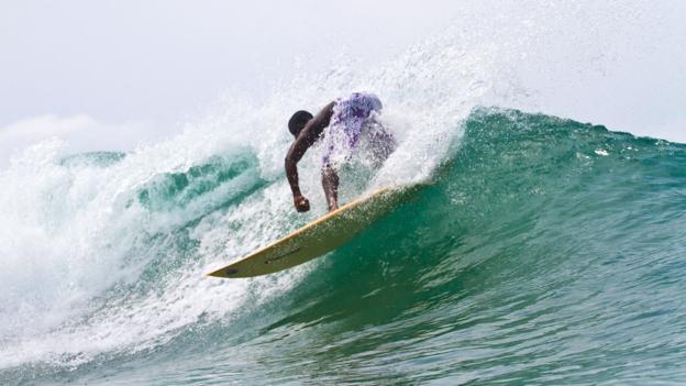 A Liberian youth catches a wave (Credit: Credit: Sean Brody)