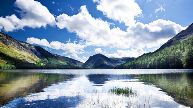 Bright skies reflect off of Buttermere Lake in Cumbria (Credit: Credit: JPagetRMphotos/Alamy)