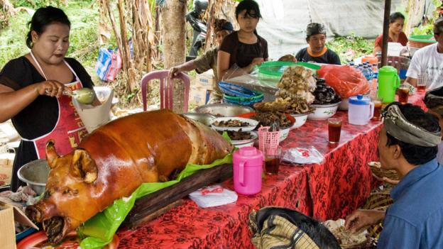 People feast on babi guling after it’s been cooked for around two hours (Credit: Credit: age fotostock/Alamy)