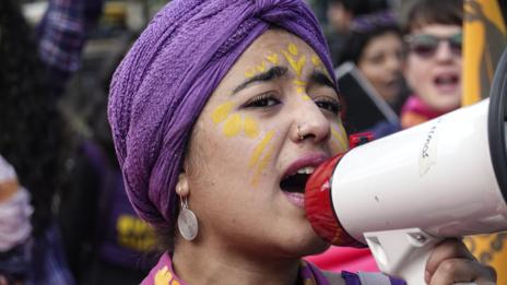 A woman speaks into a megaphone 