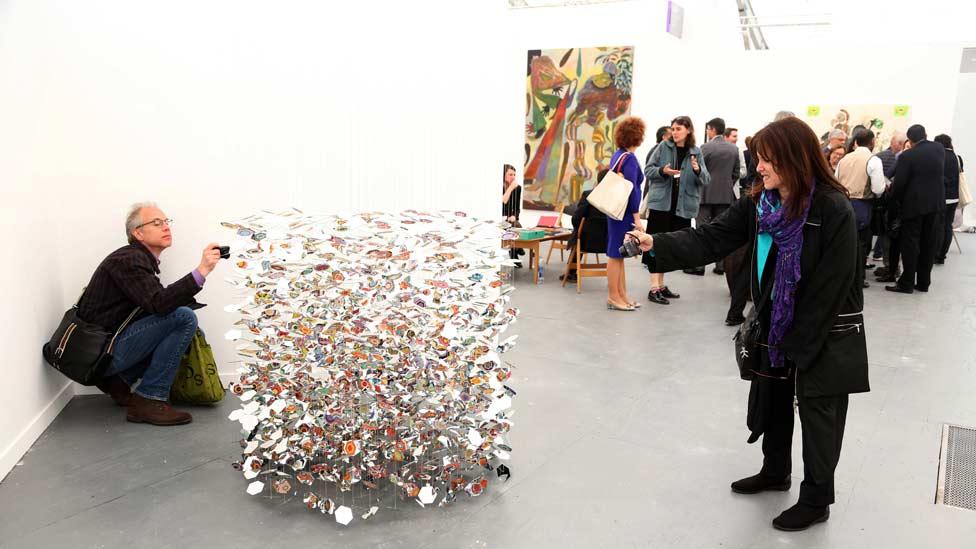 Frieze visitors are keen to photograph the multi-coloured mobile sculpture by Pae White, entitled Underthere, (2013). (Zuma/Rex Features) Frieze visitors are keen to photograph the multi-coloured mobile sculpture by Pae White, entitled Underthere, (2013). (Zuma/Rex Features)
