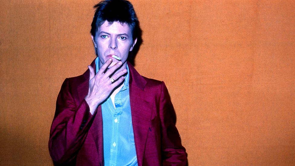 A 28-year-old Bowie is pictured at Hilversum TV studios in 1975, smoking meditatively and wearing a striking pink suit. (Rex Features) A 28-year-old Bowie is pictured at Hilversum TV studios in 1975, smoking meditatively and wearing a striking pink suit. (Rex Features)