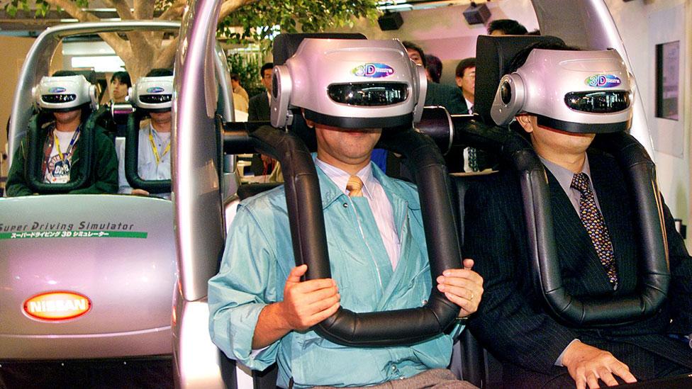 Passengers ride a virtual reality driving simulator at the Tokyo Motor Show. (Getty Images) Passengers ride a virtual reality driving simulator at the Tokyo Motor Show. (Getty Images)