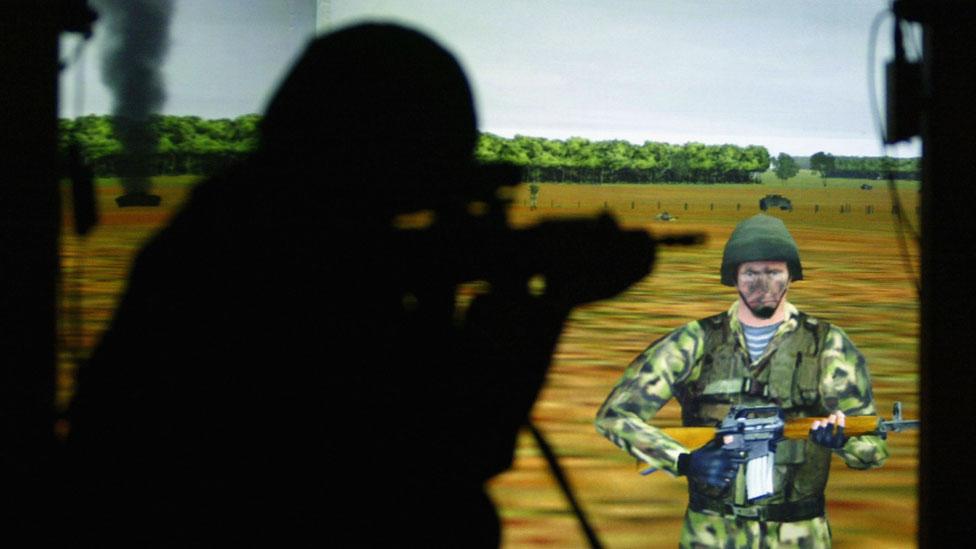 A British Army soldier takes aim at a video screen displaying a battlefield scenario. (Ian Waldie/Getty Images) A British Army soldier takes aim at a video screen displaying a battlefield scenario. (Ian Waldie/Getty Images)