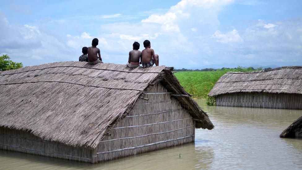 Children sit on the roof of a submerged home after a 2016 flood of the Brahmaputra River in South Kamrup, India (Credit: Getty Images) Children sit on the roof of a submerged home after a 2016 flood of the Brahmaputra River in South Kamrup, India (Credit: Getty Images)