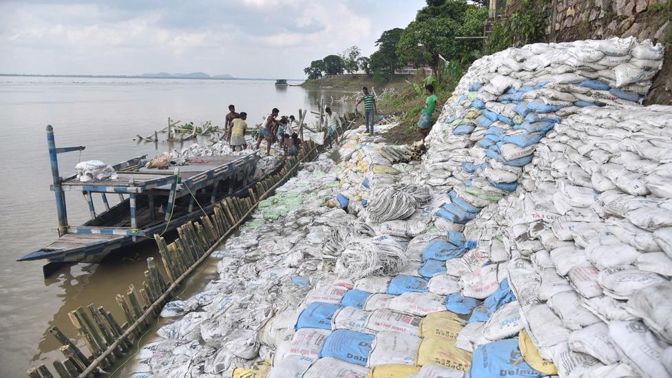 Labourers pile sand bags to try to protect a bank of the Brahmaputra from erosion in Guwahati (Credit: Getty Images) Labourers pile sand bags to try to protect a bank of the Brahmaputra from erosion in Guwahati (Credit: Getty Images)