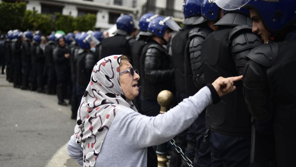 An elderly woman talks to the Algerian security forces during the recent protests (Credit: Getty Images)