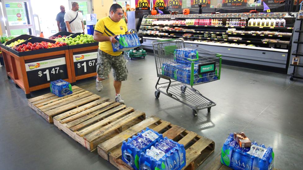 Man picking up bottled water in supermarket Man picking up bottled water in supermarket