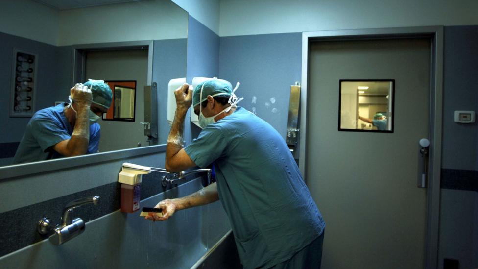 A doctor washing his hands before entering the operating room (Credit: Getty Images)