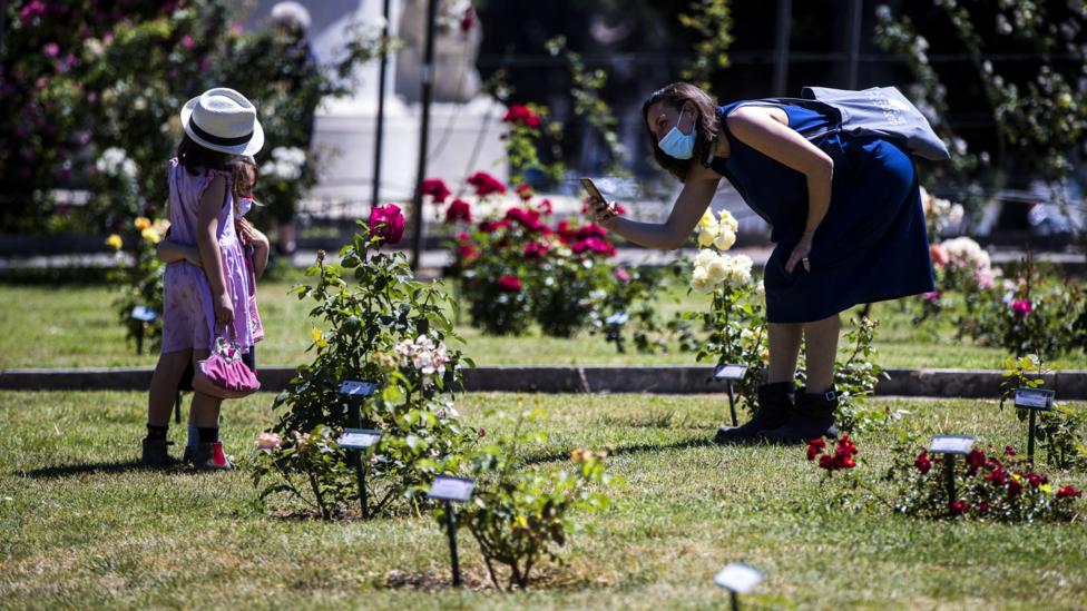 People wearing face masks visit the Rome Rose Garden in May 2020 (Credit: Getty Images)