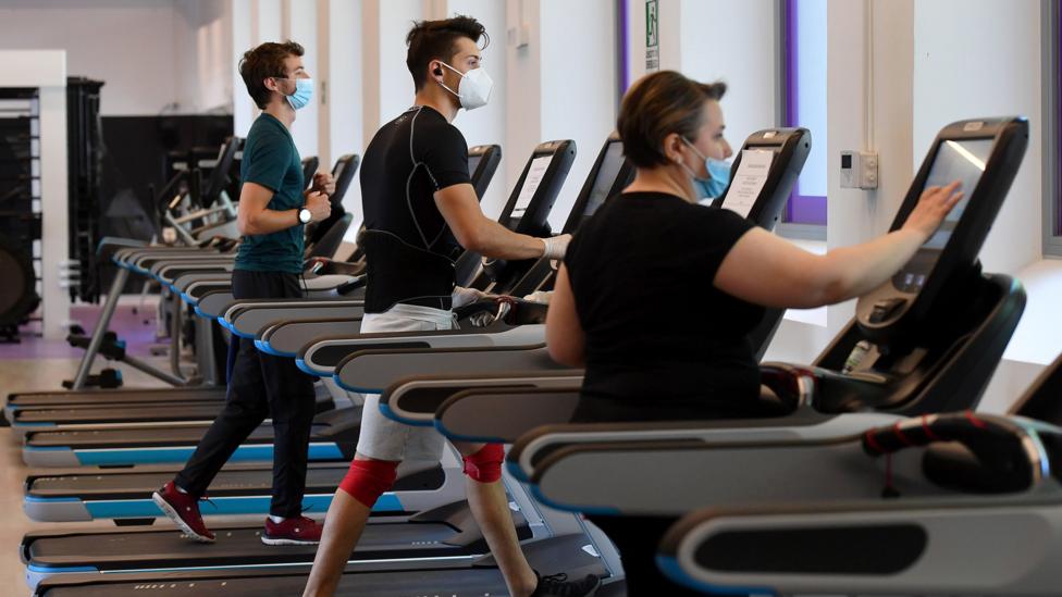 People work out at a gym in Rome in May 2020, carefully spaced apart and wearing masks (Credit: EPA)