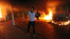 A man waves a rifle outside the US conculate in Benghazi (Copyright: Getty Images)